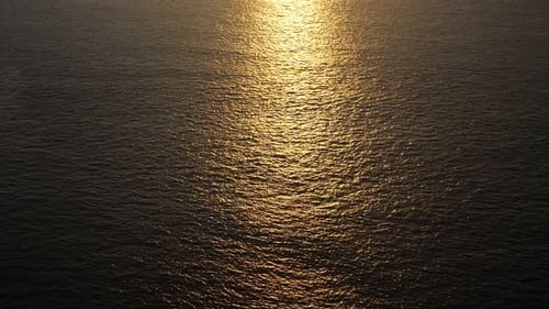 Marvelous Bright Yellow Sunlight Reflected in Calm Endless Ocean at Sunset
