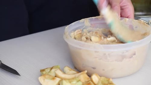 Mixing Apples for Pie Filling in Kitchen