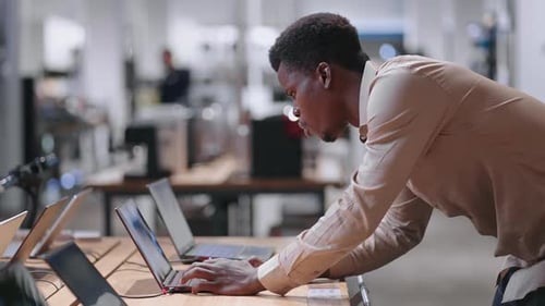 Adult Black Man is Buying Laptop for Work in Electronics Shop Testing New Model in Trading Hall