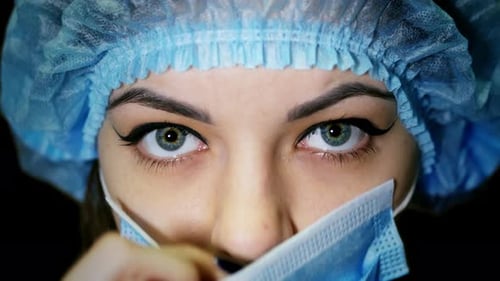 Close Up of Woman Wearing Surgical Cap and Mask