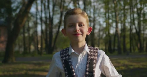 Smiling Boy with Backpack in Park