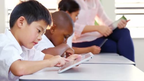 School kids and teacher using digital tablet in classroom