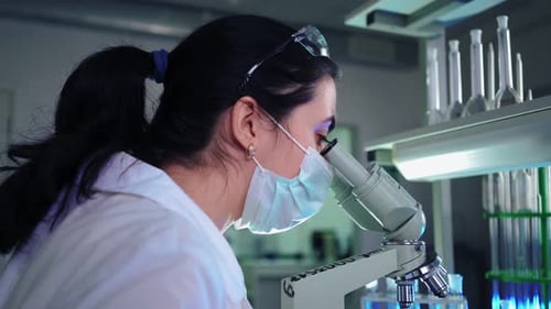 Woman Scientist Using Microscope in Lab