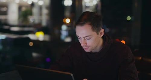Man Working By Laptop PC in a Night Cafe
