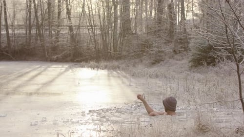 Man Emerging from Hole in Frozen Pond