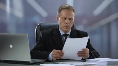 Head of Company Checking Reports, Attentively Reading Documents at Office Desk