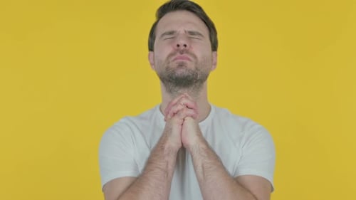Junger Mann betet zu Gott auf gelbem Bildschirm