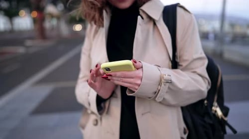 Young Woman Using Smartphone on City Street