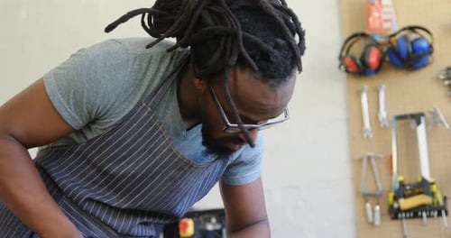 Man Measuring Wood with Tape Measure and Pencil
