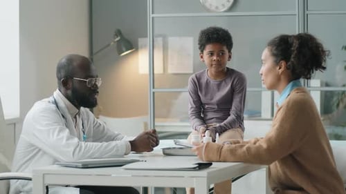 Doctor Consults with Parent and Child in Clinic