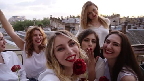 Grupo de mulheres jovens estão em um terraço se divertindo rindo