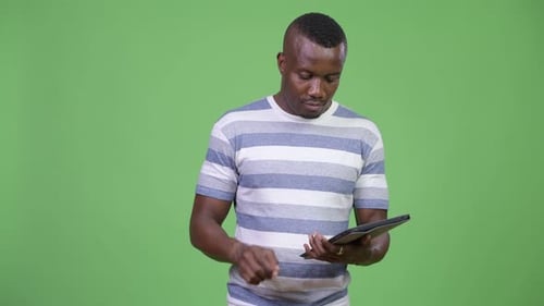 Young Adult Using Tablet on Green Screen