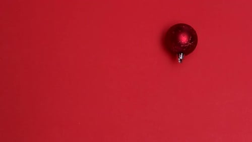 Red christmas bauble spinning on red background