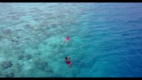 Aerial nature of luxury tourist beach holiday by aqua blue ocean with white sand background of a day