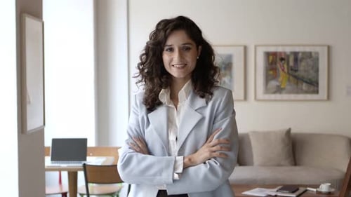 Smiling Woman in Business Attire Stands Indoors