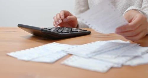 Frau berechnet die Ausgaben zu Hause