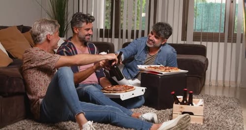 Glückliche Männer jubeln Bierflaschen beim Pizza-Essen