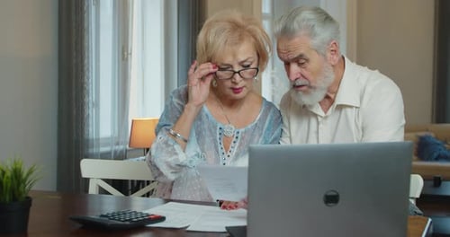 Older Couple Reviewing Bills at Home