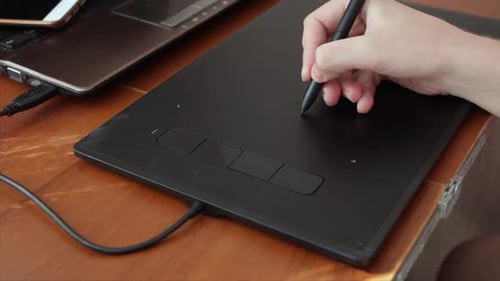 Hand Using Pen on Graphics Tablet on Desk