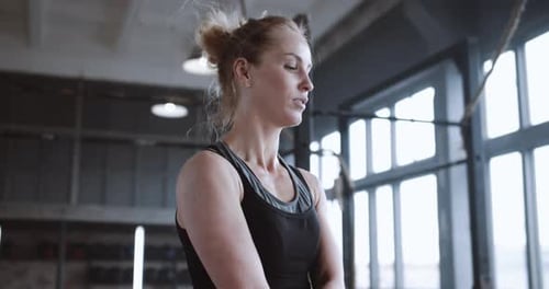 Nahaufnahme Junge athletische blonde Frau, die mit Springseil trainiert müde und verschwitzt in großer atmosphärischer