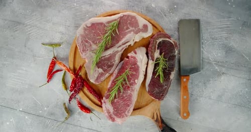 Raw Beef on a Cutting Board with a Knife Rotates.