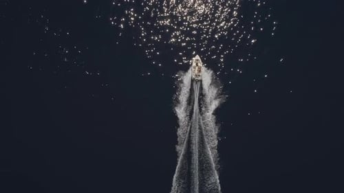 Aerial view of small speed boat with trailing wake on sea.