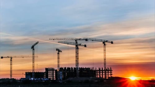 Construction Cranes Silhouetted at Colorful Sunset Timelapse