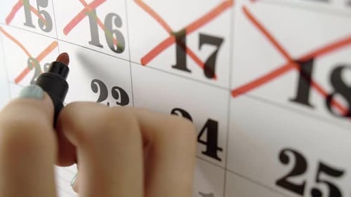 Female Hand Crosses with Red Marker the Calendar Day 23. Slow Motion Shot. Close Up