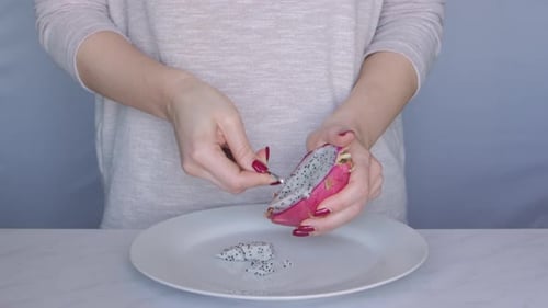 Junge Frau schneidet Drachenfrucht