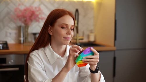 Woman With Red Hair Plays With Pop-It Toy