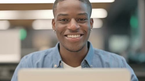 Young Man Working on Laptop Computer Smiling