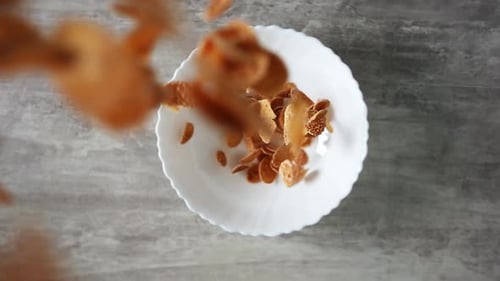 Corn Flakes Falling Into White Bowl