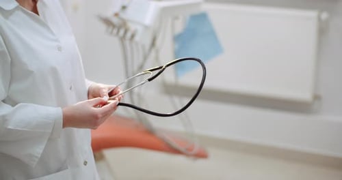 Doctor Puts On Stethoscope in Medical Office