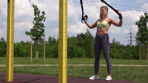 A Beautiful Fit Woman Inclined Pull-ups at an Outdoor Gym