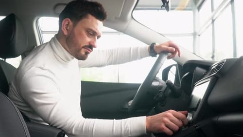 Man Adjusts Controls Inside Car During Daytime