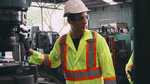 Group of Factory Workers Using Machine Equipment in Factory Workshop