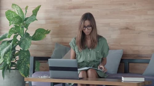 Woman Works at Laptop, Writing in Notepad