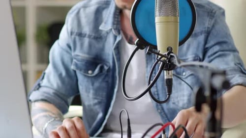 Man Recording Podcast in Home Studio with Microphone