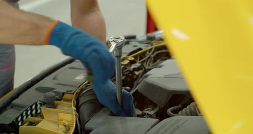 Close Up Footage of Professional Mechanic Working on a Vehicle in a Car Service. Engine Specialist