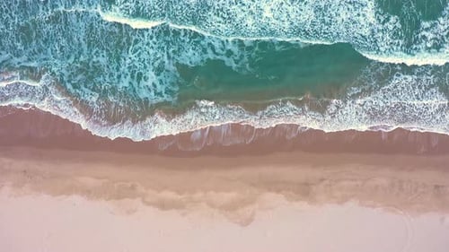 Vista aérea de las olas chocan contra la costa al atardecer