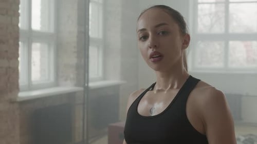 Young Adult Woman Boxing in Urban Gym