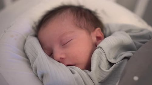 Sleeping Infant Wrapped in Blue Blanket