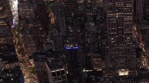AERIAL: Looking Down on Beautiful Manhattan at Night Surrounded By Skyscrapers in Busy City in