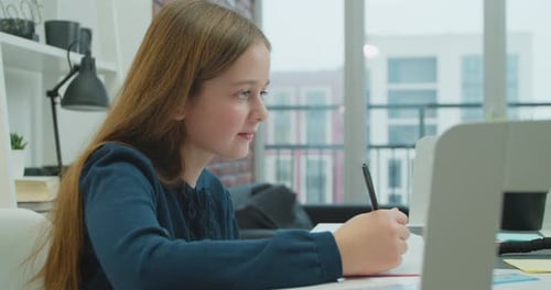 Girl Writing in Notebook at Desk