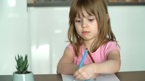 Girl Drawing with Colored Pencils Indoors