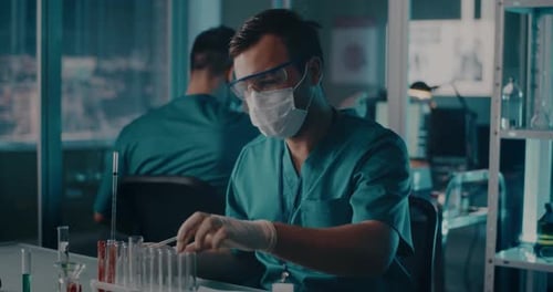 Male Doctor Making Notes and Researching Vaccine