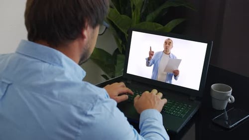 Man Typing at Laptop During Virtual Meeting