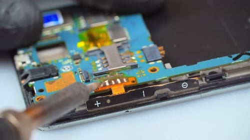 der Master-Lötkolben verlötet die Handyplatine mit einem Lötkolben