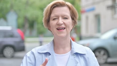 Woman Gives Thumbs Up on City Street