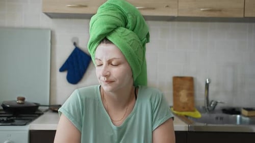 Young Woman with Facial Mask in Kitchen